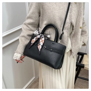 Litchi pattern leather tote bag with scarf detail and adjustable strap on a model