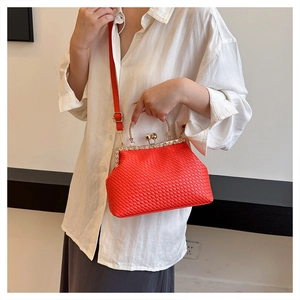 Detail of red woven evening bag with gold clasp and pearl diamond embellishment