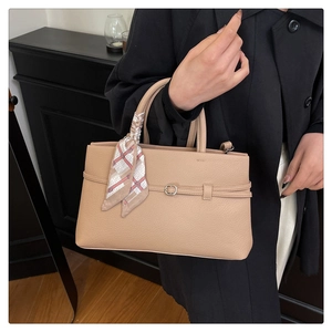 Detail of beige lychee leather tote bag with elegant checkered silk scarf wrap on handle