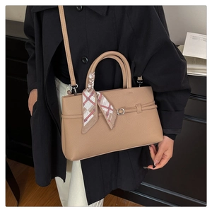 Detail of khaki tote bag featuring lychee grain leather and decorative silk scarf handle