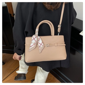 Close-up of beige lychee texture tote bag with elegant silk scarf and silver metal buckle