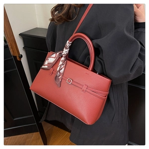Detailed texture of lychee grain leather tote with decorative silk scarf on handle