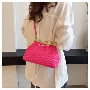 Detail of fuchsia woven crossbody bag with vintage gold metal clasp and chain strap