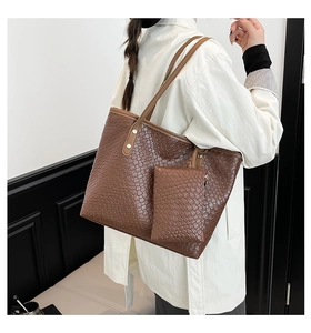Detail view of a large woven tote bag in dark brown with matching accessory pouch