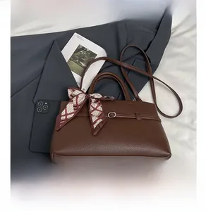 Detail showing brown lychee grain leather texture and silk scarf wrapped on the tote handle