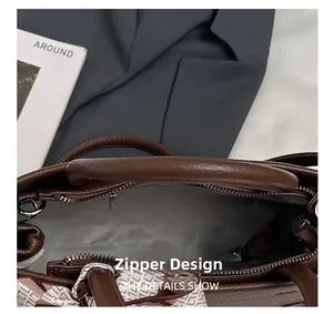 Detail of the zipper closure on a dark brown lychee leather tote bag with silk scarf