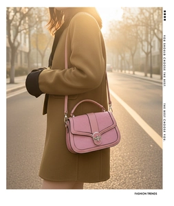 Detail of pink handbag with woven texture flap and metallic oval twist lock closure