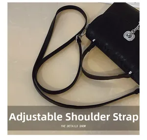Close-up of the adjustable leather shoulder strap and silver metal buckle of the messenger bag