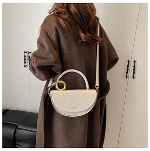 Detail of cream leather half-moon bag with gold knot hardware and fashion logo