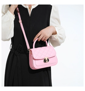 Detail van roze gewatteerde crossbodytas met een gouden draaisluiting en handvat luxe