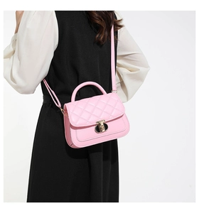 Detail of pink quilted flap bag with metallic rotary lock and matching shoulder strap
