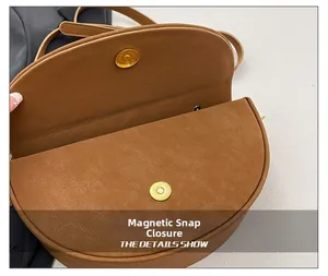 Detail view of brown saddle bag showing magnetic clasp closure and premium texture