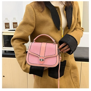 Detail of pink leather handbag with striped fabric flap and silver metal twist lock