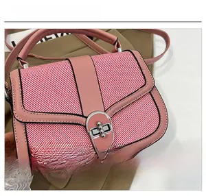 Close-up of pink striped fabric handbag with leather trim and silver metal twist lock