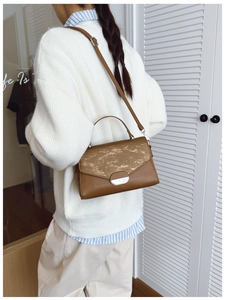 Sac bandoulière vintage marron avec poignée, design minimaliste dans un décor élégant