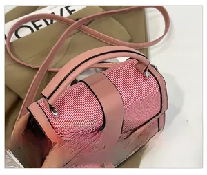 Detail of the pink leather and woven fabric contrast with a silver twist-lock closure