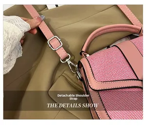 Detail of pink PU leather handbag featuring detachable shoulder strap and silver hooks