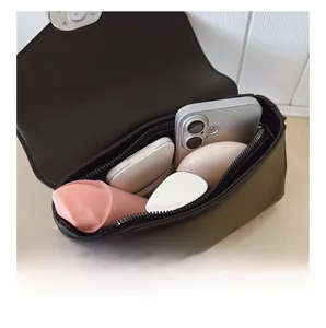 Vue détaillée de l'intérieur d'un sac rétro montrant sa capacité pour téléphone et maquillage