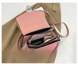 Pink patchwork crossbody bag with open flap showing multi-layer interior storage details