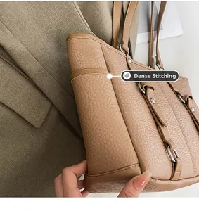 Close-up of light brown tote bag showing fine stitching and silver buckle detail