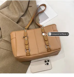 Size comparison between camel tote bag and iPhone 12 showing large capacity and dimensions