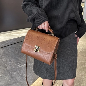 Vintage dark brown square shoulder bag with embossed floral patterns and bronze lock