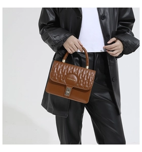 Detailed view of caramel brown quilted leather handbag with chic gold clasp and fashion logo