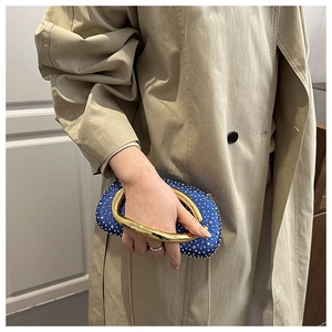 Detail of blue rhinestone oval evening bag with a designer gold metallic top handle