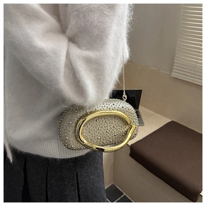 Detail of silver rhinestone evening bag with elegant gold metal ring handle and chain