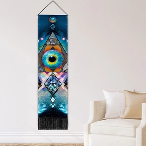 Colorful surreal eye planet tapestry with black tassels on modern white wall