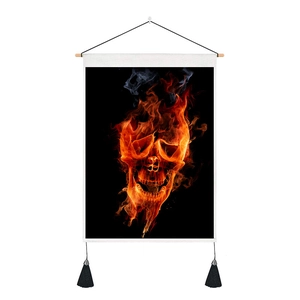 Détail d'une tapisserie crâne de feu avec tige en bois et pompons noirs décoratifs
