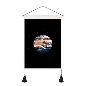 Tapestry wall art featuring a colorful planet print and black tassels on a wooden rod