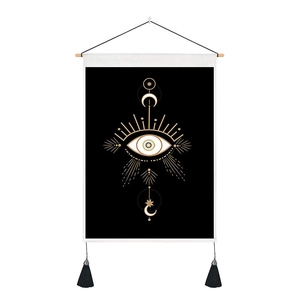 Detail of bohemian wall tapestry featuring celestial sun, moon phases, and black tassels