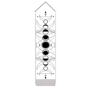 Close-up of black moon phases print on white fabric wall tapestry with bottom tassel
