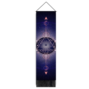 Detail of celestial eye tapestry featuring black tassels and wooden hanging rod