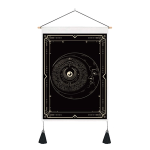 Detail of mystic moon and eye tapestry featuring black and gold printing with wooden rods