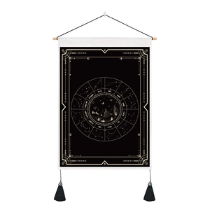 Close-up of astrology tapestry with gold zodiac ring, moon print, and black tassels