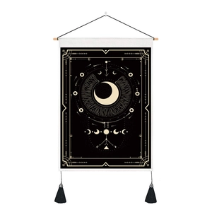 Detail of mystic moon phase tapestry featuring golden patterns and black tassels on wood bar