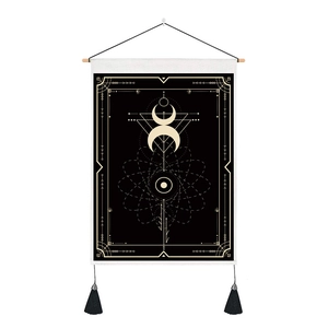 Detail of tarot tapestry with golden moon phases, black fringe, and wooden hanging rod