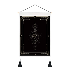 Detail of black tarot tapestry with gold UFO and jellyfish patterns, wood rod and tassels