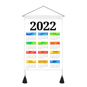 Macro shot of 2022 fabric wall calendar with wooden rod and black tassel details