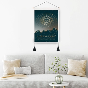 Celestial sun art tapestry with gold printing and black tassels hanging on a white wall