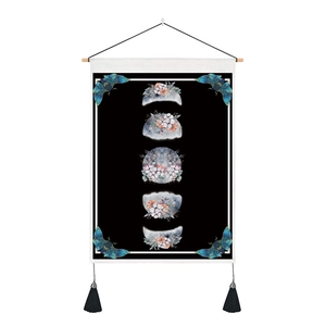 Detail of bohemian moon phase tapestry with floral botanical patterns and black tassels