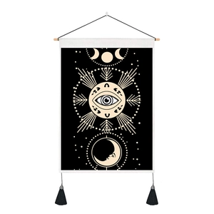 Detail of bohemian moon phase tapestry with all-seeing eye and elegant black tassels