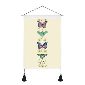 Detail of bohemian tapestry featuring butterfly moon phases and black bottom tassels