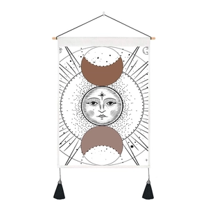 Detail of bohemian moon phase tapestry with wooden rod and black tassel accents
