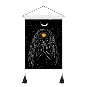 Detail of bohemian tapestry featuring moon phase girl with elegant black tassels