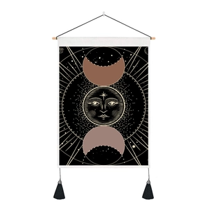 Detail of bohemian tapestry featuring celestial moon phases and sun with elegant tassels