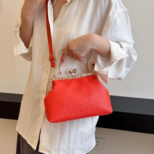 Red woven texture handbag with pearl clasp and gold handle, styled on white shirt