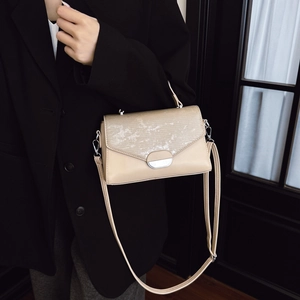 Sac à bandoulière beige chic avec rabat texturé et fermoir magnétique argenté élégant